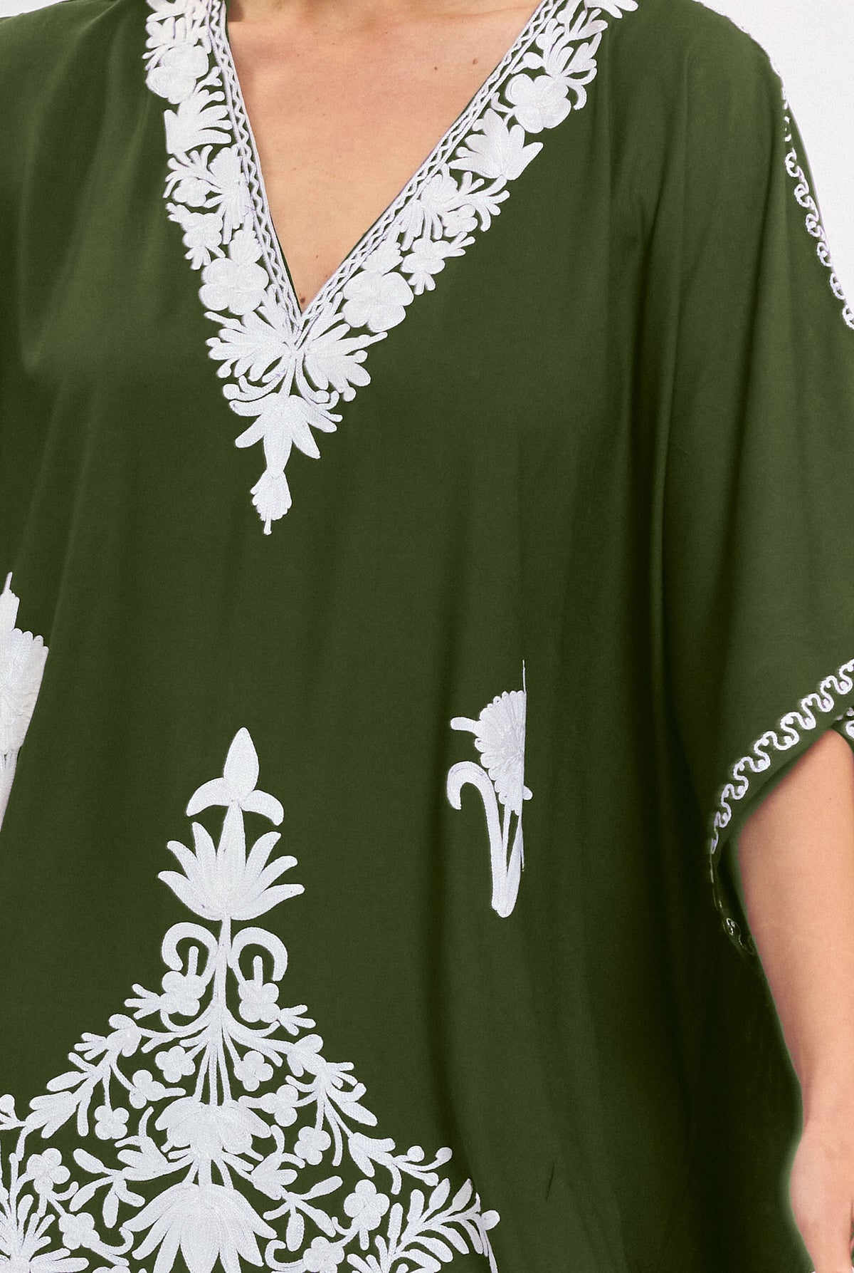 Close-up of the hand-embroidered V-neckline on the olive Kashmir cotton kaftan, ivory threadwork