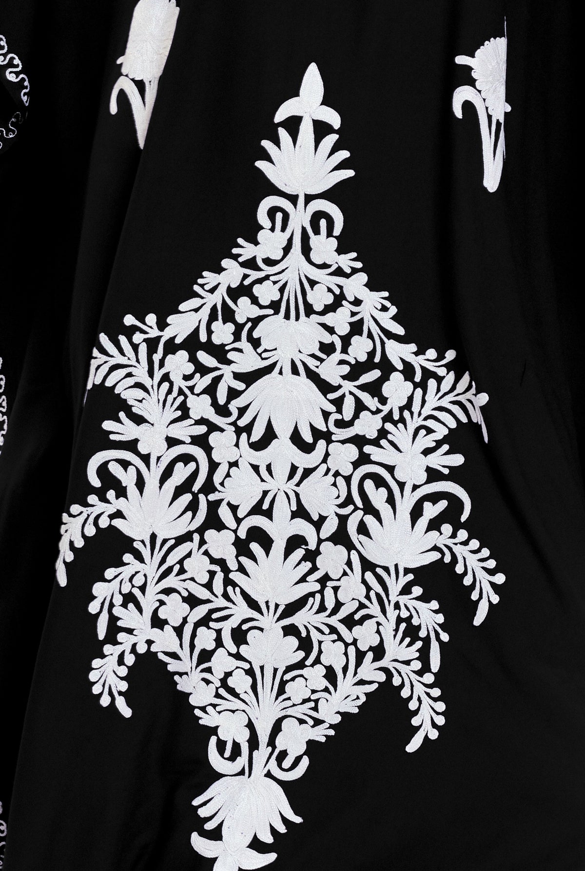 Detail of the white hand-embroidered floral panel on the black Kashmir cotton kaftan