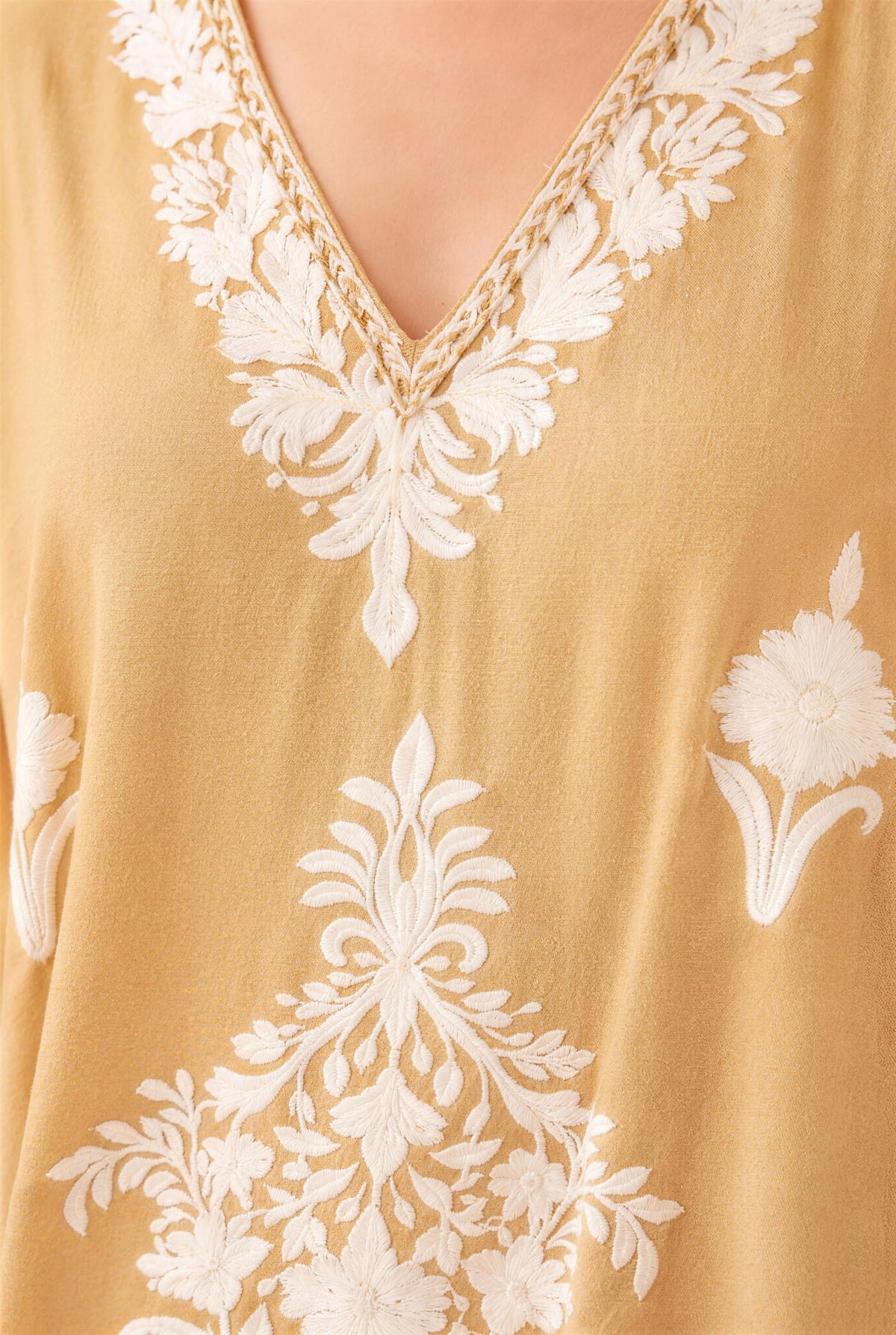 Close-up of the white floral embroidery on cappuccino Kashmir cotton