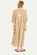 Model wearing the sand Kashmir cotton kaftan, back view with lotus emblem