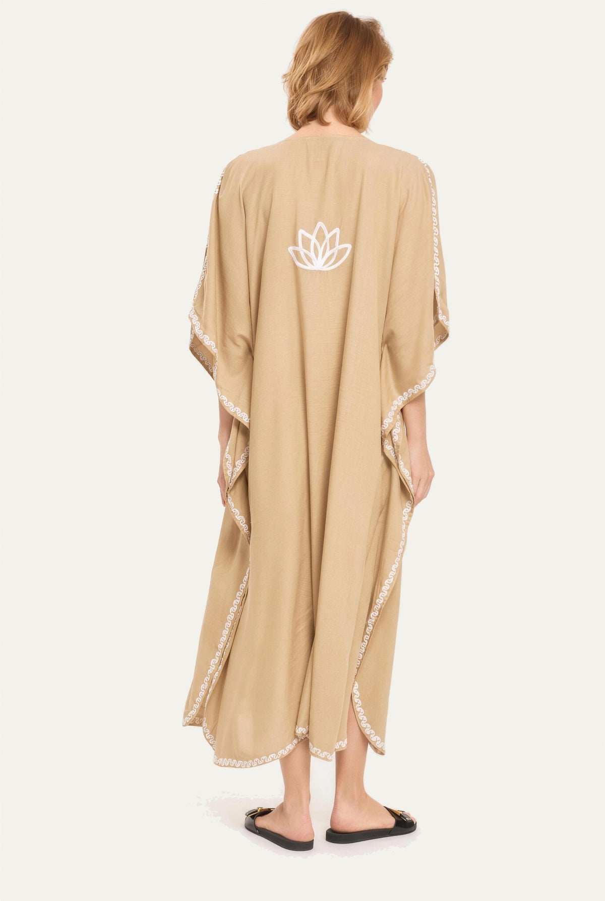 Model wearing the sand Kashmir cotton kaftan, back view with lotus emblem