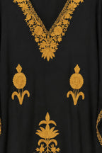 Close-up of the mustard hand embroidery at the neckline of the black Kashmir cotton kaftan