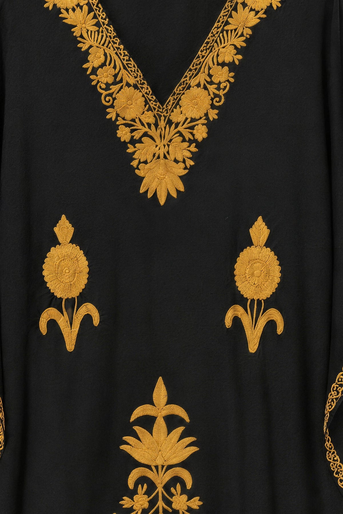 Close-up of the mustard hand embroidery at the neckline of the black Kashmir cotton kaftan