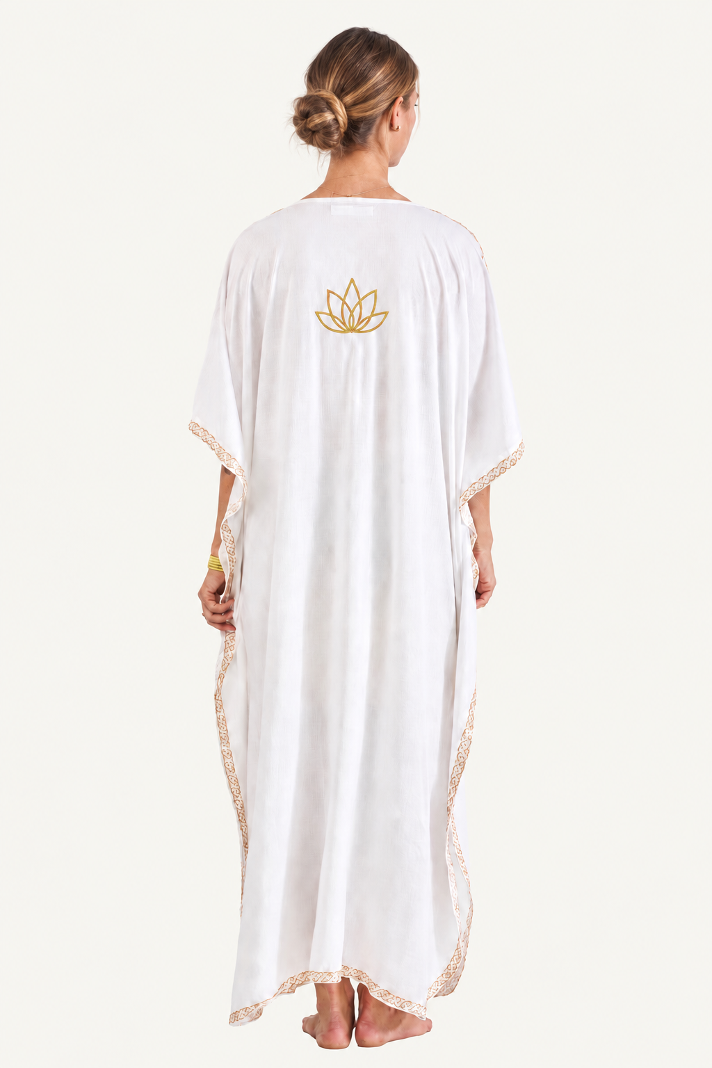 Woman wearing the white Kashmir cotton butterfly kaftan, back view showing the mustard gold lotus motif