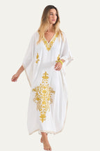 Woman wearing the white Kashmir cotton butterfly kaftan with mustard gold embroidery, front view