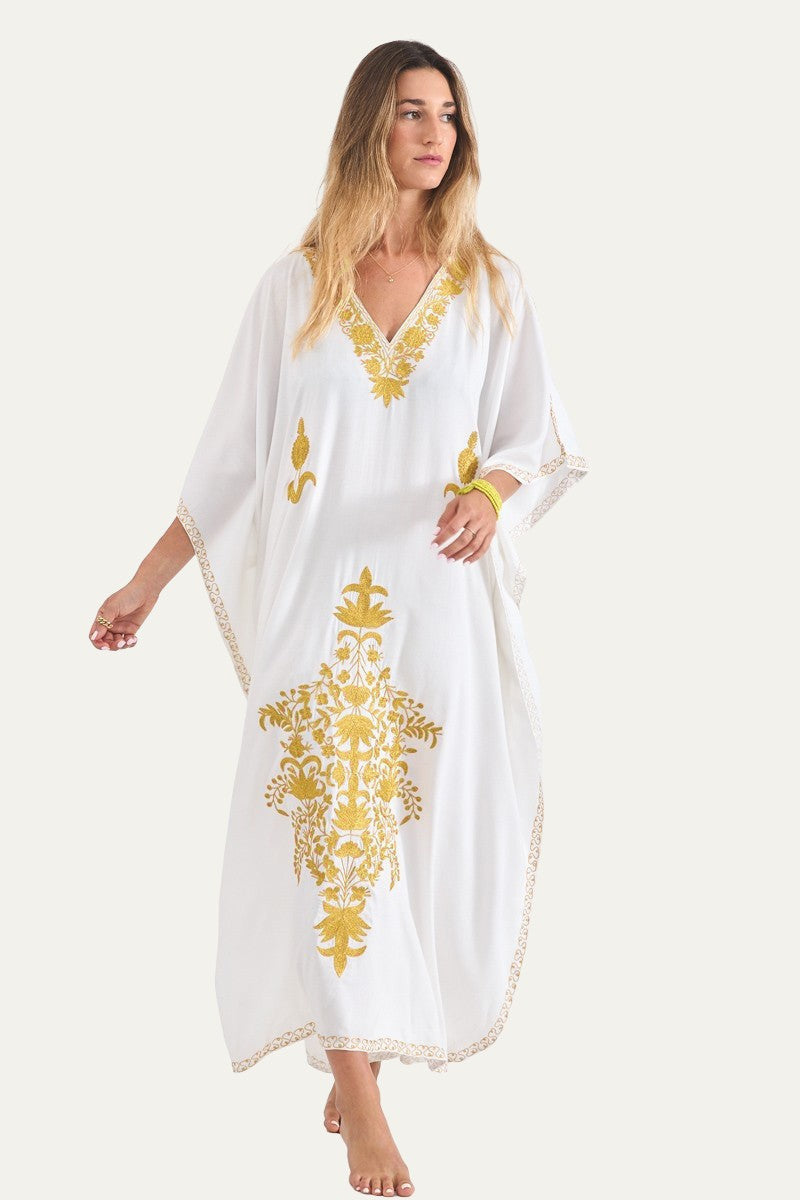Woman wearing the white Kashmir cotton butterfly kaftan with mustard gold embroidery, front view